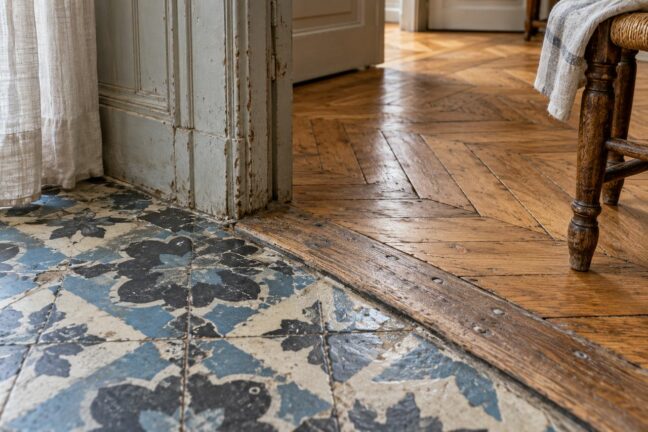 Parquet, carreaux de ciment et seuil ancien portent une part de l’histoire de la maison.